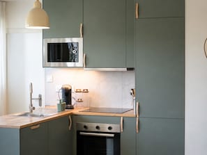 Eine moderne Küche mit integriertem Mikrowellenherd, Backofen und Kaffeemaschine.