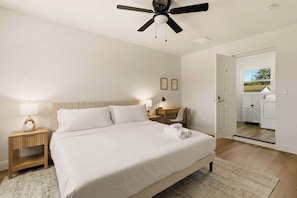 A hotel bedroom with a bed, bedside tables, a ceiling fan, and a view of the outside. - Host Hubble Private Rooms Edmond Circle (Auburndale)