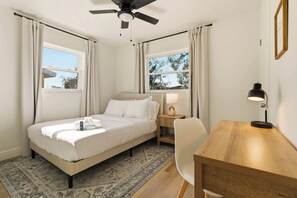 A hotel room with a bed, a desk, a chair, a nightstand, a lamp, and a ceiling fan. - Host Hubble Private Rooms Edmond Circle (Auburndale)