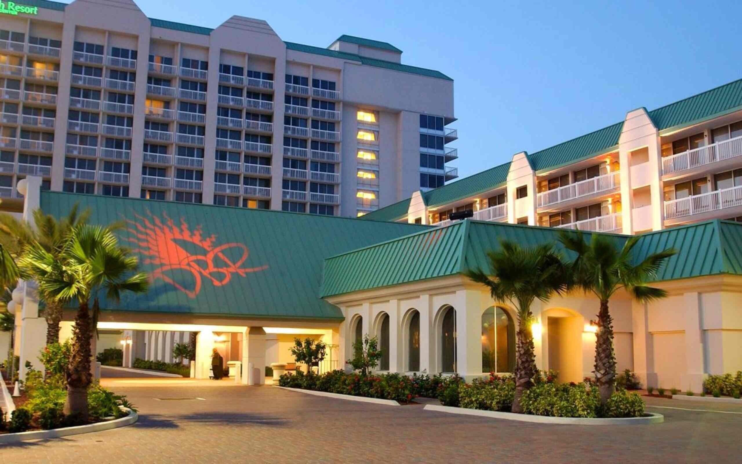 A hotel with a large building in the background and a smaller structure in the foreground with a distinctive logo.