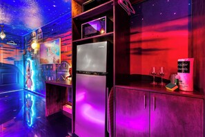 A kitchen with a refrigerator, a microwave, and a wine glass set on the counter.