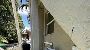 Una zona de bugaderia amb dues rentadores blanques i una finestra gran.