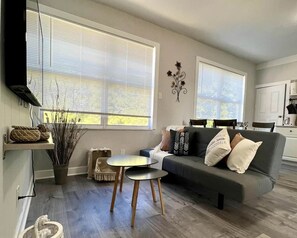 A modern living room with a grey sofa, a small round table, and a potted plant. - Modern Apartment near Brickell & Coral Gables 3 (Miami)