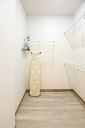 A laundry room with a drying rack, a hanging clothes rack, and a folded ironing board. - Lakefront 5BR on Rush Lake, Private Dock + Kayaks (New York Mills)