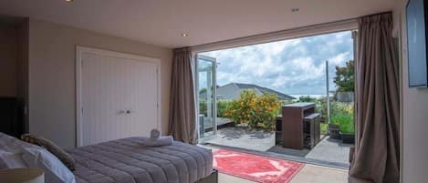 Un dormitorio con cama, ventana y vistas al exterior.