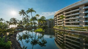Ein Resort mit Pool, Palmen und einem modernen Gebäude.