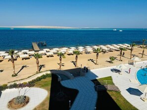 A beachside resort with a swimming pool, sun loungers, and palm trees. - Blue Haven H 101 Nubian The view Hurghada (hurghada)