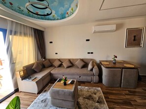 A modern living room with a sectional sofa, a coffee table, and a side table. - Blue Haven H 101 Nubian The view Hurghada (hurghada)
