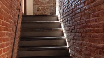 A staircase with a brick wall on one side and a metal railing on the other.