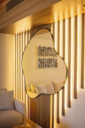Ein modernes Interieur mit einer Couch, einem an der Wand befestigten abstrakten Kunstwerk und vertikalen Hol zleisten.