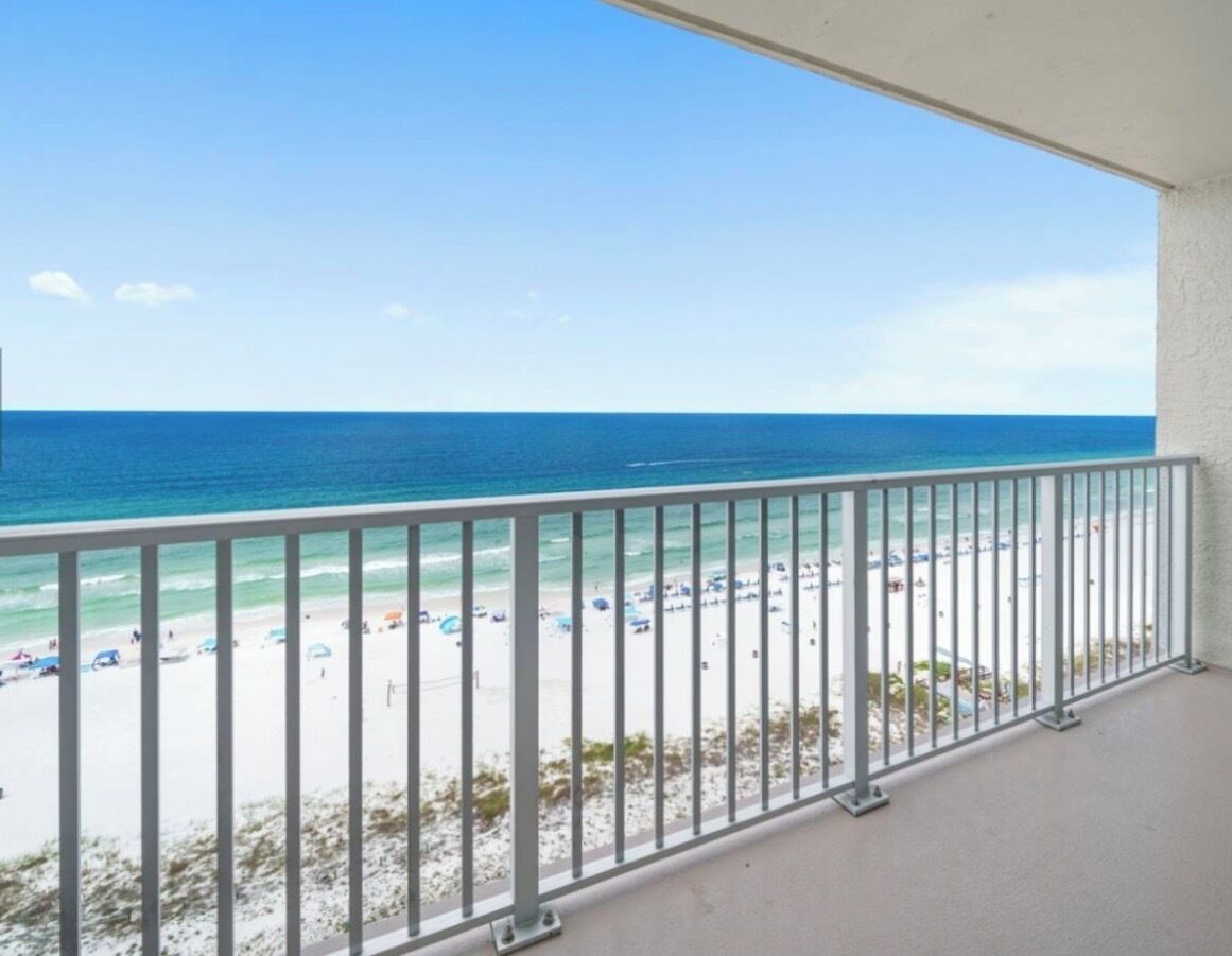 Ein Balkon mit Blick auf Strand und Meer.