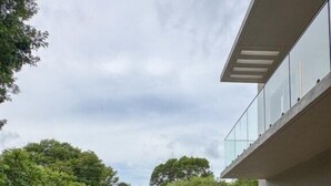 A modern outdoor swimming pool with a brick patio, surrounded by greenery and a contemporary building. - Tropical, Large Modern Keys, New Island Mansion with a pool & 2 boat docks (Key Largo)