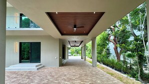 A covered walkway with a brick floor, leading to a building entrance. - Tropical, Large Modern Keys, New Island Mansion with a pool & 2 boat docks (Key Largo)