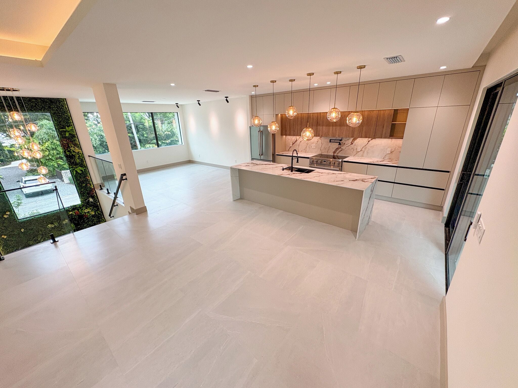 A spacious kitchen with a central island, modern appliances, and pendant lighting.