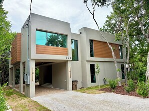 Ein modernes, zweistöckiges Haus mit Flachdach, großen Fenstern und der sichtbaren Hausnummer 109.