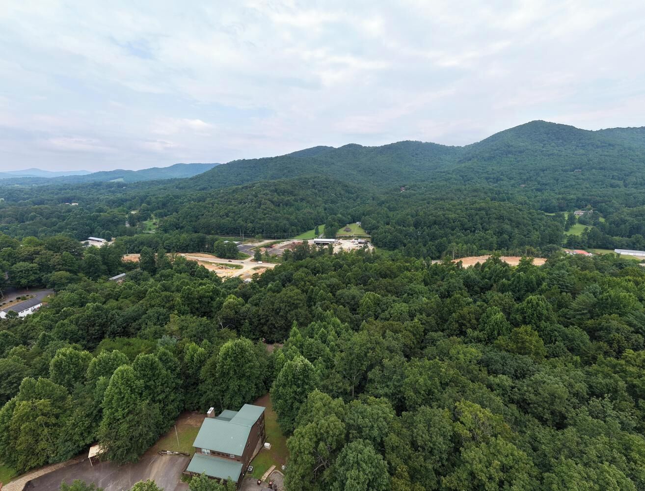 A forested area with a building and a road.