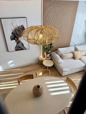 A modern living room with a round table, a sofa, a wall-mounted lamp, and a framed artwork. - Viktoriia's Home in Orihuela (Orihuela)