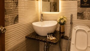 Un baño con lavamanos blanco, un espejo, inodoro y ducha.