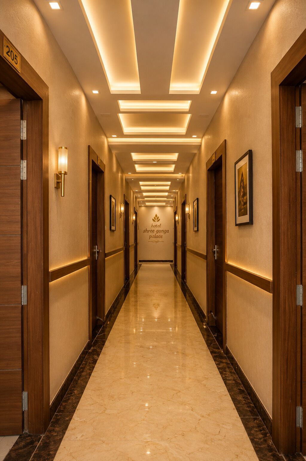 Un pasillo de hotel con piso de mármol, puertas de madera y luminarias fijadas a la pared.