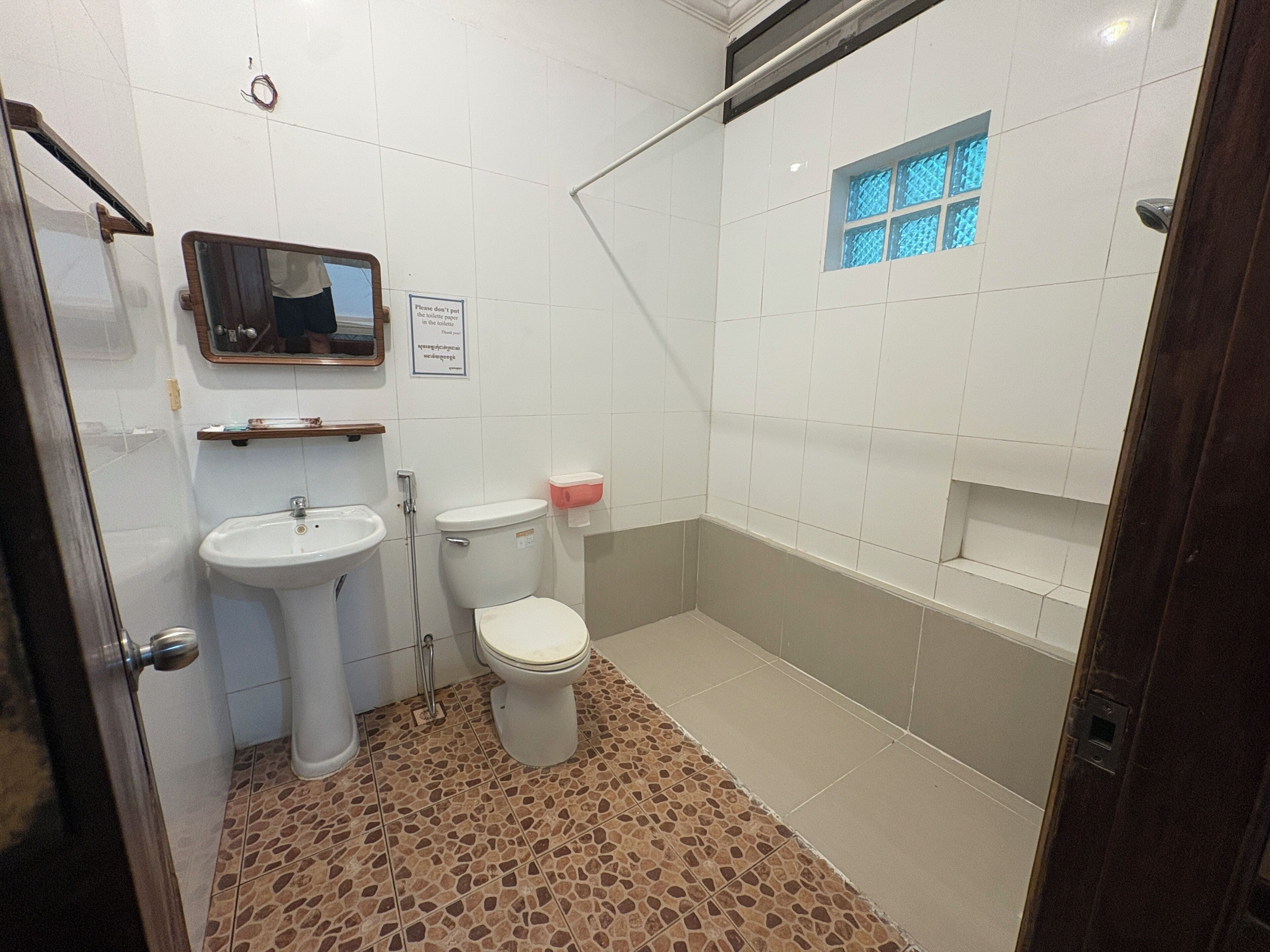 Une salle de bain avec un lavabo, des toilettes et une douche.