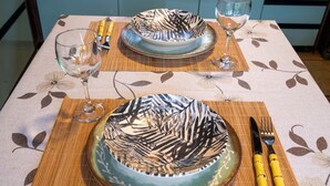 A table set with a patterned plate, a glass, a fork, and a knife.