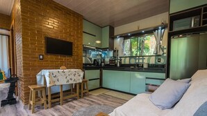 A compact living space with a kitchen, a dining area, and a sofa.