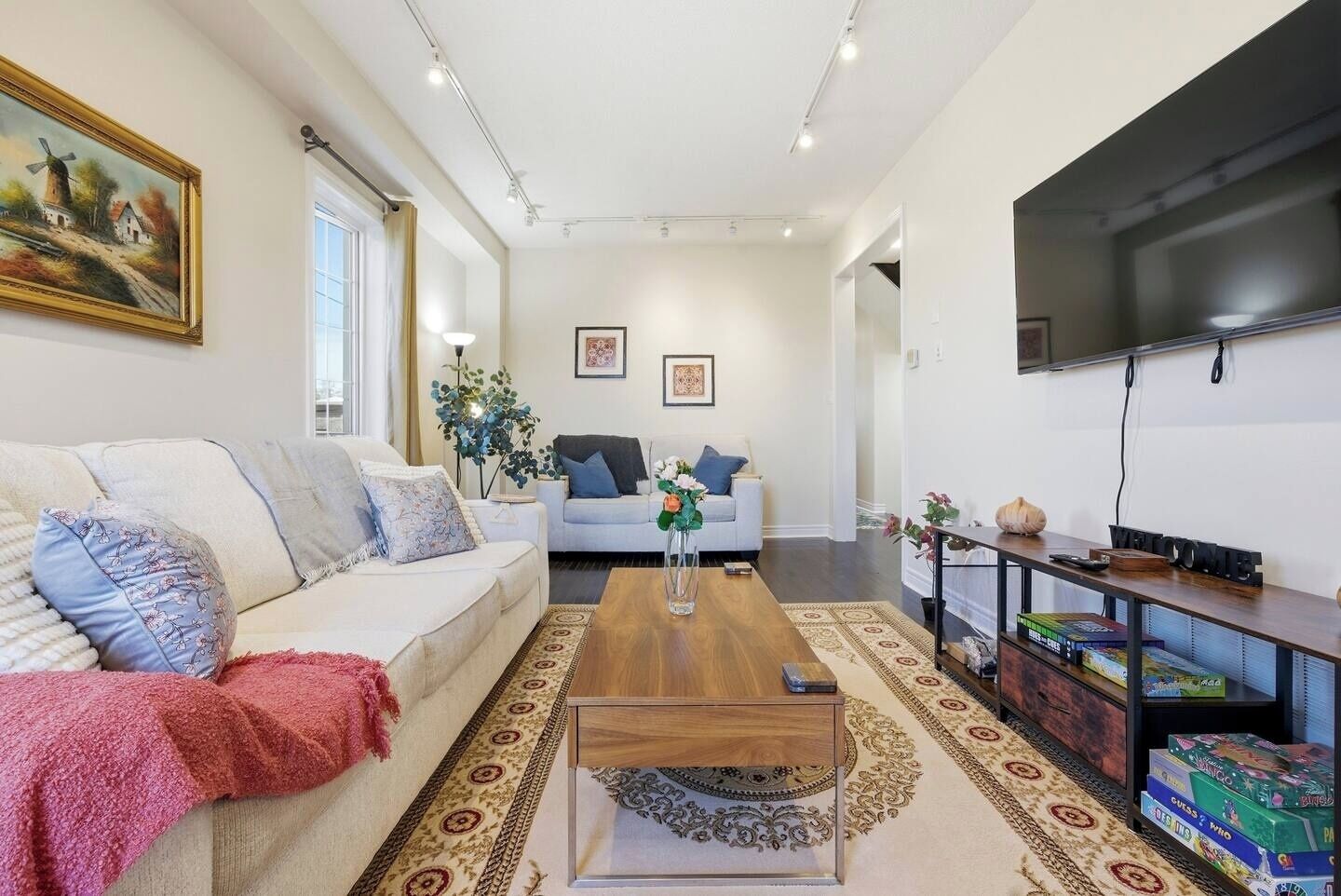 A modern living room with a sofa, coffee table, and a flat-screen TV.
