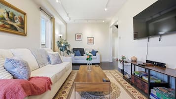 A modern living room with a sofa, coffee table, and a flat-screen TV.