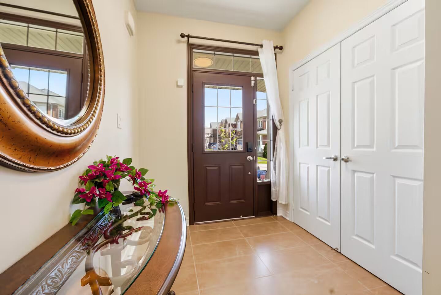 A hallway with a brown door, a white door, and a mirror on the wall.