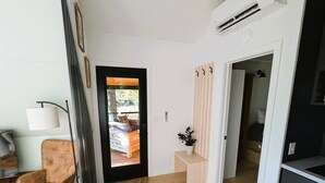 Ein modernes Interieur mit Holzboden, einer Sitzecke mit einem Sessel, einem kleinen Tisch und einer Tür zu einem anderen Raum.