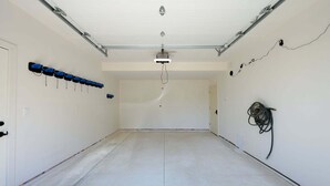 A spacious, empty room with a high ceiling, a door on the left, and a wall-mounted cable on the right. - Milky Way Mountain Chalet I Private Hot Tub I Great Views I Bunk Room I Discounted Attractions (Fraser)