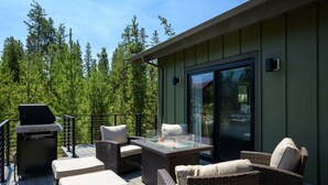 An outdoor deck with wicker furniture, a grill, and a glass-top table with a fire feature. - Milky Way Mountain Chalet I Private Hot Tub I Great Views I Bunk Room I Discounted Attractions (Fraser)