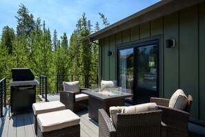 An outdoor deck with wicker furniture, a grill, and a glass-top table with a fire feature. - Milky Way Mountain Chalet I Private Hot Tub I Great Views I Bunk Room I Discounted Attractions (Fraser)