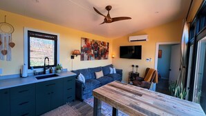 Una cucina moderna con lavello integrato, un tavolo da pranzo e una ventola a soffitto.