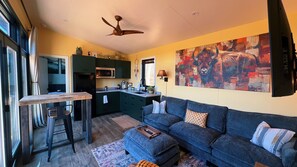 A compact living space with a kitchenette, a sofa, a dining table, and a ceiling fan. - Bison Farm - Vista Cabin (2 BR option) (Culpeper)