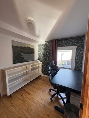 Una habitación con escritorio, silla y un cuadro en la pared.