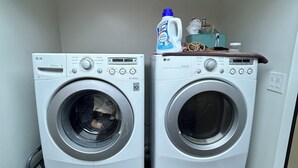 Duas máquinas de lavar roupa da LG Direct Drive, brancas e de abertura frontal, numa lavanderia com ladrilhos estampados.