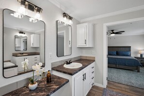 Een moderne badkamer met een wastafel, een grote spiegel en een gootsteen.