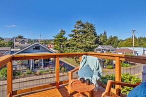 Um deck de madeira com vista para casas e árvores.