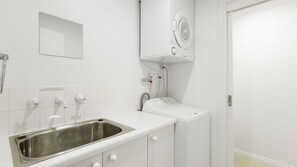 A modern bathroom with a stainless steel sink, a mirror, a towel rack, and a white toilet. - Osprey 1 - Queenscliff (QUEENSCLIFF)