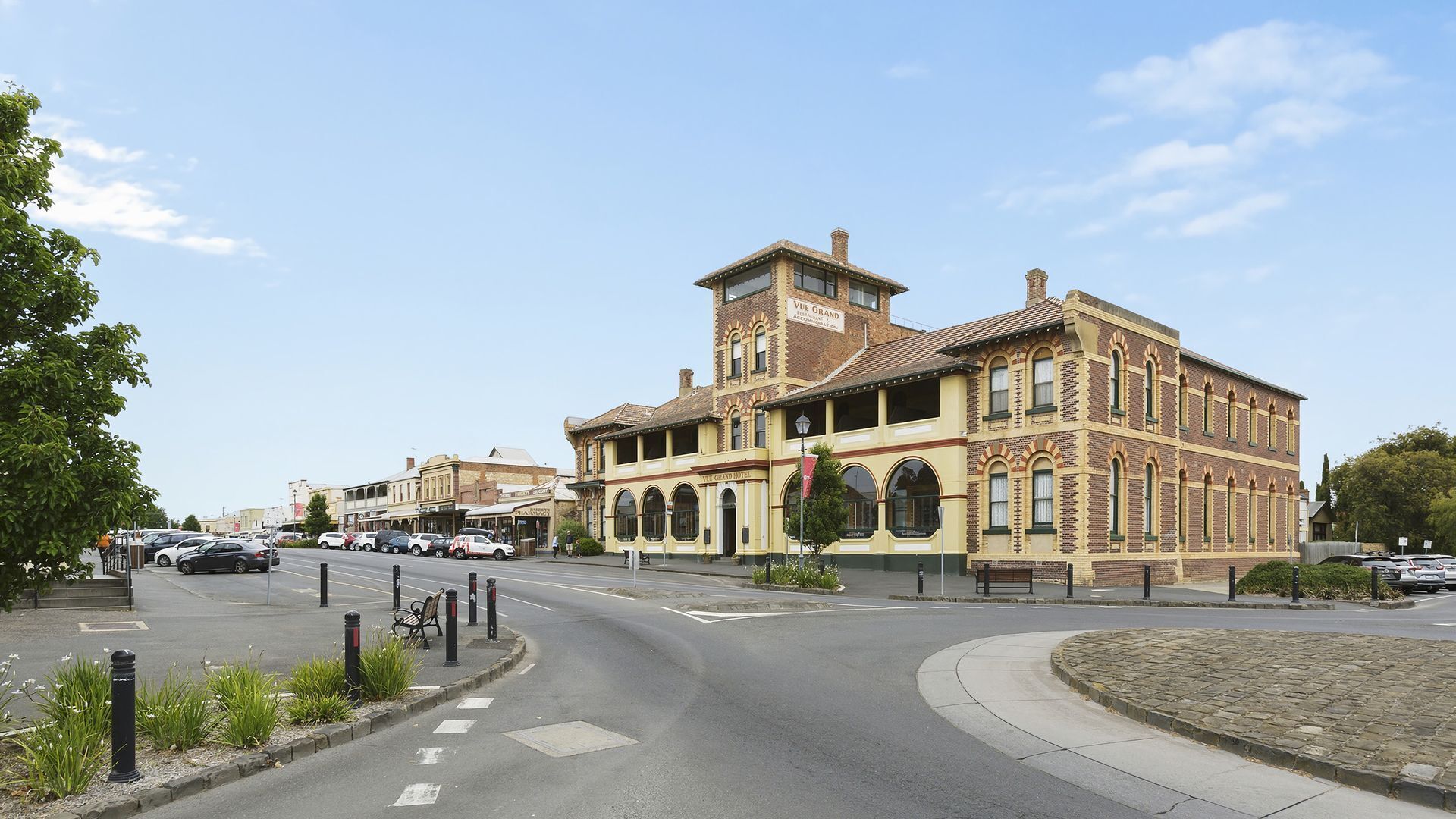 A historic building with a prominent corner location, large windows, and a visible sign for the Vue Grand Hotel.