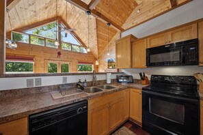 A kitchen with wooden cabinets, a microwave, a stove, and a dishwasher. - Spacious Mountain Getaway Minutes from Boone (Boone)