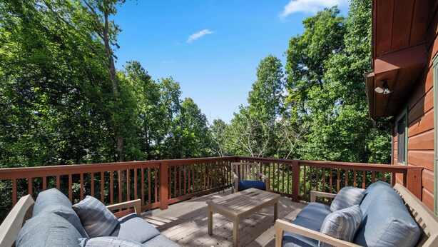 A wooden deck with outdoor furniture, surrounded by trees. - Spacious Mountain Getaway Minutes from Boone (Boone)