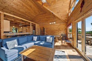 A wooden interior with a sectional sofa, a wooden table, and a view through a glass door. - Spacious Mountain Getaway Minutes from Boone (Boone)