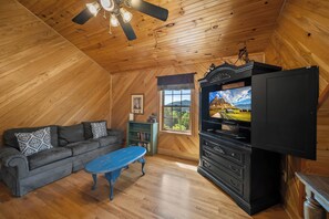 A cozy room with a wooden ceiling, a television, a sofa, and a small table. - Mountain Retreat with Long-Range Views Near Boone (Boone)