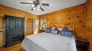 A bedroom with a bed, wooden walls, a ceiling fan, and a dresser. - Mountain Retreat with Long-Range Views Near Boone (Boone)