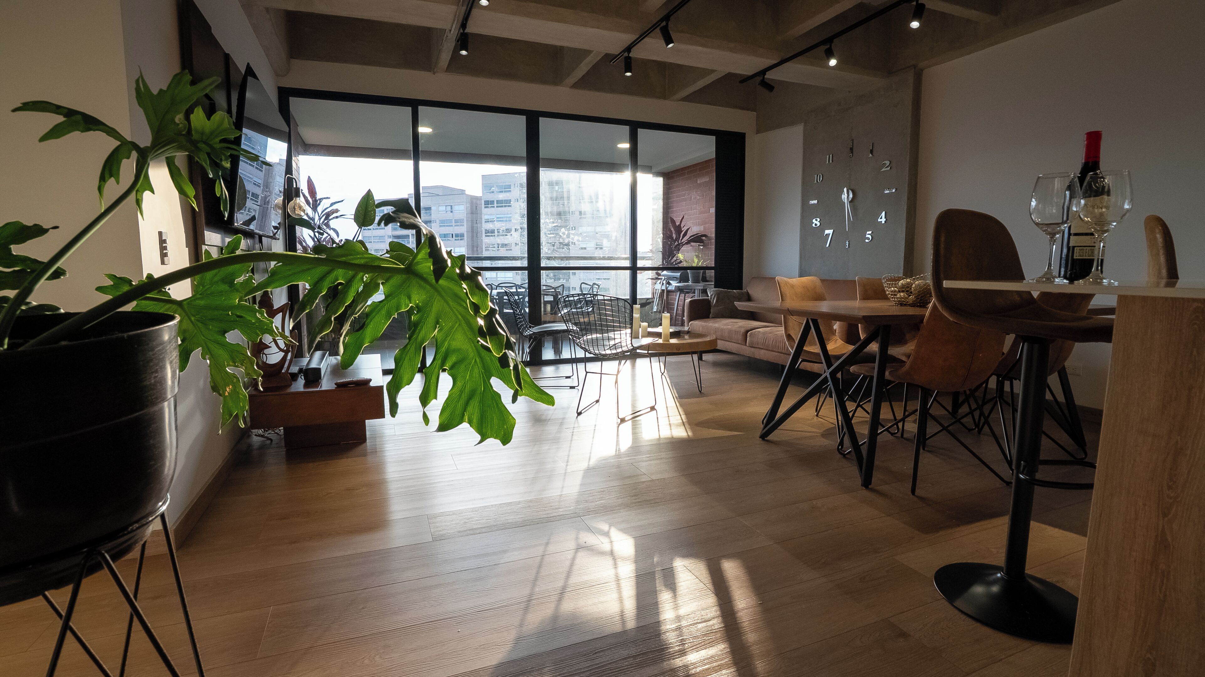 A modern interior with a dining area, large windows, and a view of the city.