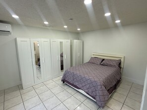 A bedroom with a bed, a wardrobe, and a ceiling with recessed lighting. - Cozy 1-bedroom studio in delightful Miami with AC comfort (Miami)