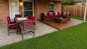 A patio with a wooden table and chairs, a sofa set, and a small coffee table. - Cozy Katy Home near Katy Mills, Restaurants, and Family Attractions (Katy)