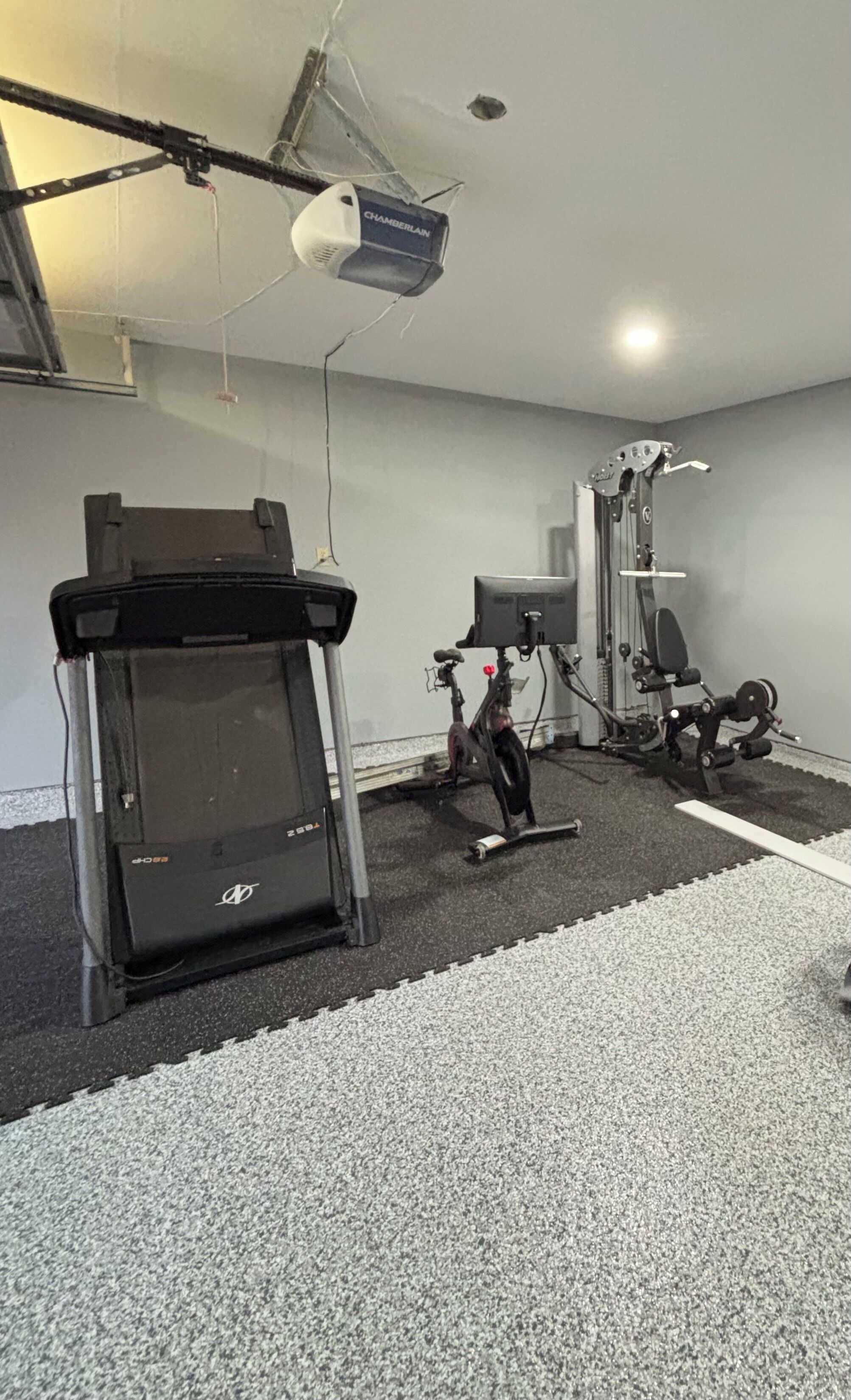 A gym with exercise equipment including a treadmill, stationary bike, and weight machines.